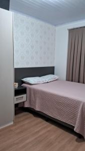 a small bedroom with a bed and a window at Casa 5 estrelas in Cascavel