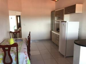 a kitchen with a table and a white refrigerator at Recanto da Baía in Baía Formosa +2 photos