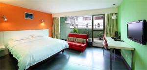 廣州的住宿－廣州市白宮酒店，一间卧室配有一张床、一张书桌和一台电视。