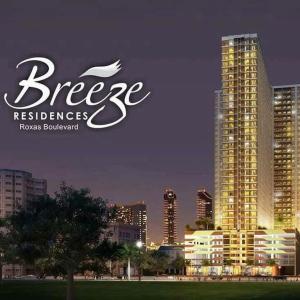 eine Skyline einer Stadt mit einem großen Gebäude in der Unterkunft Juvrey Studio-Unit Breeze Residences in Manila