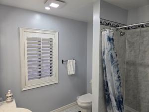 ein Badezimmer mit Dusche und Toilette und einem Fenster in der Unterkunft Charming 3 Bedroom home near the lake in Mississauga + 113 Fotos