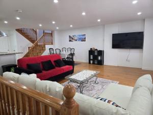 ein Wohnzimmer mit einem Sofa und einem roten Sofa in der Unterkunft Charming 3 Bedroom home near the lake in Mississauga