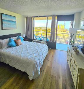 a bedroom with a bed with a view of a city at Ocean View Studio Condo w Balcony Pool and Free Parking in Daytona Beach +40 photos