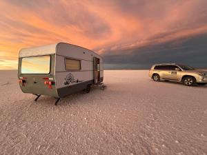 a camper and a car parked in the desert at Camper Elegance Uyuni in Carpas