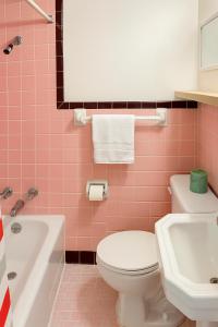 a pink bathroom with a toilet and a sink at Economy Inn in Temple