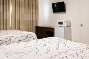 a hotel room with a bed and a microwave at Economy Inn in Temple