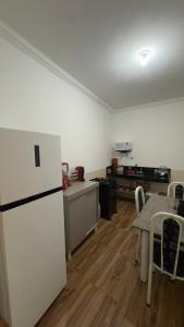 a kitchen with a refrigerator and a table with chairs at Refúgio real in Ouro Preto