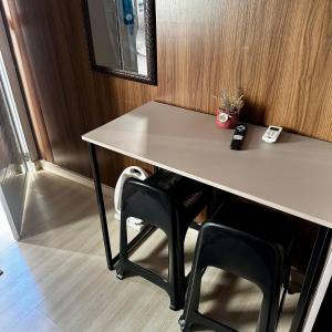 a table with two black chairs under a table at Loft Lux 5 (Smart TV, Ar condicionado, Cozinha...) in Chapecó