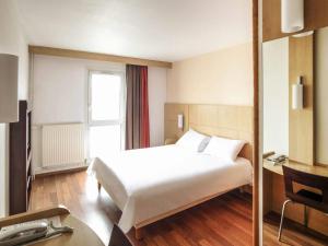 a hotel room with a white bed and a window at ibis Nancy Centre Stanislas in Nancy