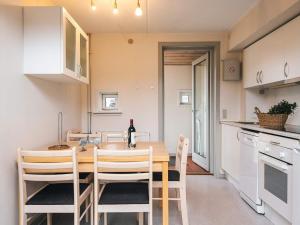 Una cocina y un comedor con mesa y sillas de madera. en 6 person holiday home in Rømø, en Sønderby