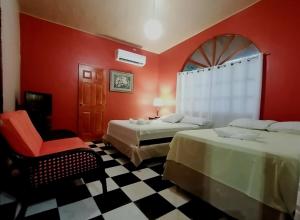 a hotel room with two beds and a chair at Hotel Rancho Infinito in El Cuco