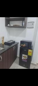 une cuisine avec un réfrigérateur et un plan de travail dans l'établissement Meg place, à Amamoli