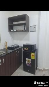 eine Küche mit Herd und Mikrowelle in der Unterkunft Meg place in Amamoli