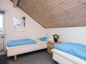 two beds in a room with a wooden ceiling at 6 person holiday home in Rømø-By Traum in Sønderby +37 photos