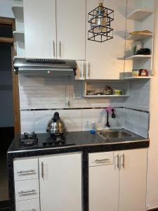 a kitchen with a stove and a sink in it at Warm and Modern in the heart of the city in Huaraz