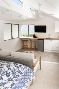 a bedroom with a bed and a kitchen with a table at BEACH Baby Cottage! in Ngunguru