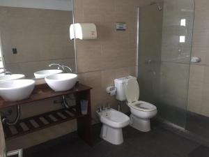 a bathroom with two sinks and a toilet and a shower at Link Cordoba Hostel in Cordoba