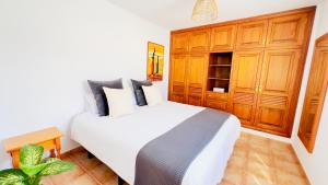 een slaapkamer met een wit bed en houten kasten bij Terraza del Mar in Arrieta