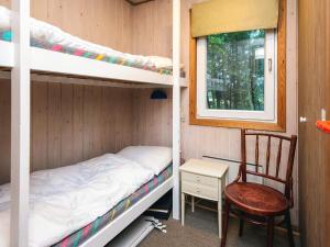 a bedroom with bunk beds and a chair and a window at Tranquil Retreat in Bolilmark-By Traum in Bolilmark