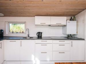 a white kitchen with white cabinets and a window at 4 person holiday home in Grenaa in Grenå +28 photos