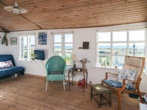 a living room with a couch and chairs and windows at 4 person holiday home in Grenaa in Grenå