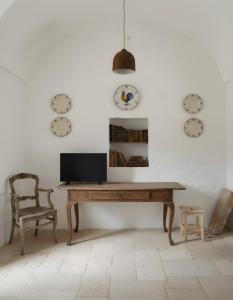 een bureau met een televisie en een stoel in een kamer bij La Posta dell'Eremo in Ostuni
