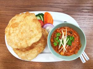 a plate with a bowl of food and a bowl of soup at Le Aura Grand - Luxury Smart Hotel in Lahore by Urban Homes in Lahore