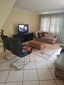 a living room with a couch and a tv at Sea Breeze Valley 2 in East London