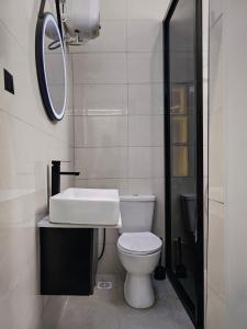 a bathroom with a toilet and a sink and a mirror at Jeffreys Apartments in Lagos