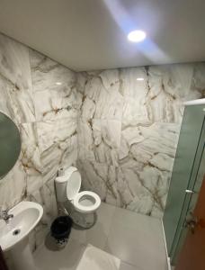 a bathroom with a white toilet and a sink at Pousada Recanto do Brás in Sao Paulo +18 photos