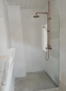 een douche met een glazen deur in een badkamer bij La Posta dell'Eremo in Ostuni