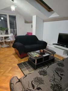 a living room with a couch and a coffee table at Apartman Laki 56 in Kaluđerica