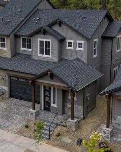 a house with a black roof and a garage at Mountain Pines Getaway in Flagstaff