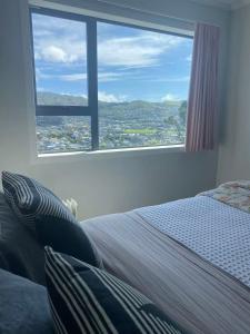 a bedroom with a bed and a large window at Relaxing rooms with mountain views, close to ferry in Wellington
