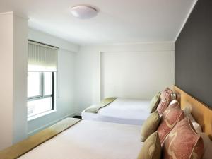 a bedroom with two beds and a window at ibis Sydney World Square in Sydney