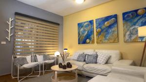a living room with a white couch and some paintings at Casa Céntrica con Roof garden y Vistas a la Ciudad in Guadalajara