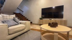 a living room with a couch and a tv at Casa Céntrica con Roof garden y Vistas a la Ciudad in Guadalajara