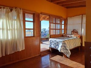 a bedroom with a bed and a large window at El terrenito in Zurumútaro