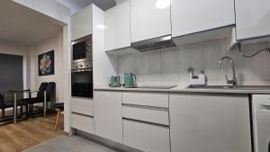 a kitchen with white cabinets and a dining room at October Nest in Funchal +5 photos