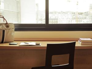 a chair sitting in front of a desk with a window at ibis Sao Paulo Barra Funda in Sao Paulo +136 photos