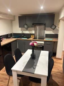 a kitchen with a table with a vase of flowers on it at TheNest in Vienne