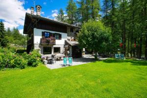 une maison avec une cour avec de l'herbe verte dans l'établissement Hotel Locanda Belvedere, à Courmayeur