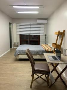 een slaapkamer met een bed en een bureau met een laptop bij House Bela Vista in Porto Alegre
