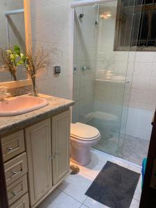 een badkamer met toilet en glazen douche bij House Bela Vista in Porto Alegre