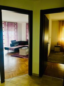 een kamer met een woonkamer met een bank en een deur bij Great Deal in Podgorica