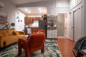 a living room with orange chairs and a kitchen at Centrally-Located Studio in DWTN Richmond in Richmond
