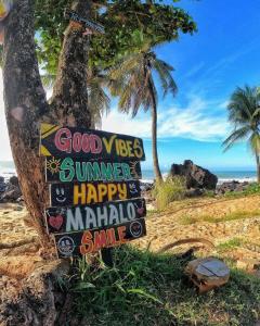 a sign on a beach with palm trees and the ocean at Recanto da Baía in Baía Formosa