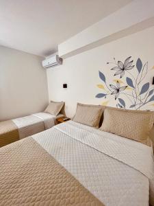 a bedroom with two beds and a mural on the wall at Pousada Solana in Salvador