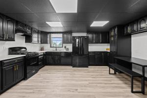 ロックアイランドにあるStylish 3BR 2BA Getaway for 8のキッチン(黒いキャビネット、黒い冷蔵庫付)