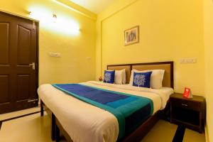 a bedroom with a large bed with blue and white pillows at Super Hotel O Diamond In in Cochin